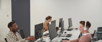 IT Developers Working at Desks in Office Side View