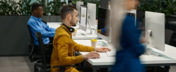 Two male employees works on computer in IT office