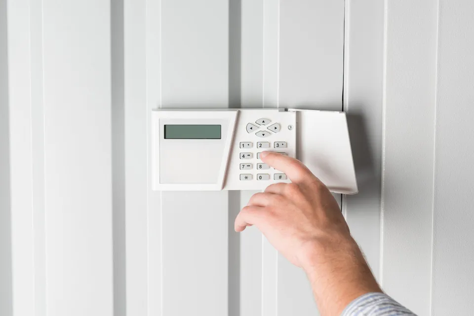 person-typing-password-on-home-security-alarm